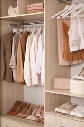 Modern wardrobe with clothes, shoes and accessories indoors