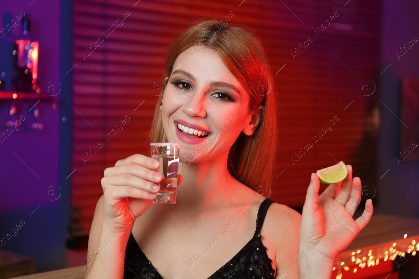 Photo of Young woman with Mexican Tequila shot in bar