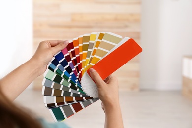 Photo of Female interior designer with color palette samples indoors, closeup