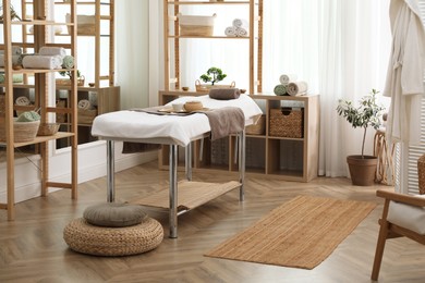 Photo of Stylish room interior with massage table in spa salon