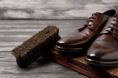 Photo of Men's leather shoes and cleaning brush on grey table