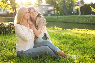 Photo of Happy mother with her daughter on green grass in park