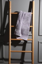 Soft terry towel on wooden ladder indoors