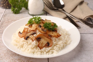 Photo of Delicious rice with parsley and mushrooms on tiled table