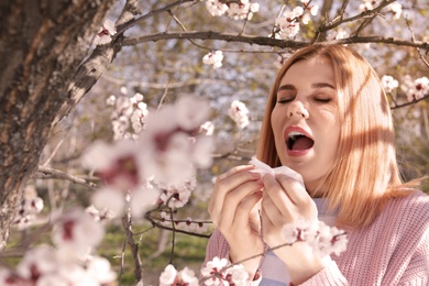 Woman suffering from seasonal allergy outdoors on sunny day