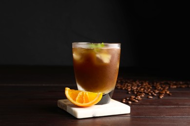 Tasty refreshing drink with coffee and orange juice on wooden table