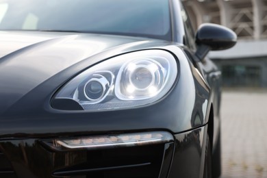 Photo of Modern black car parked outdoors, closeup view