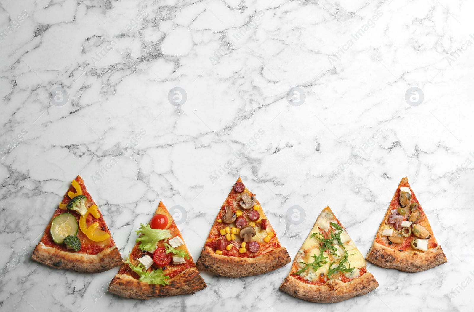 Photo of Slices of different delicious pizzas on white marble table, flat lay. Space for text