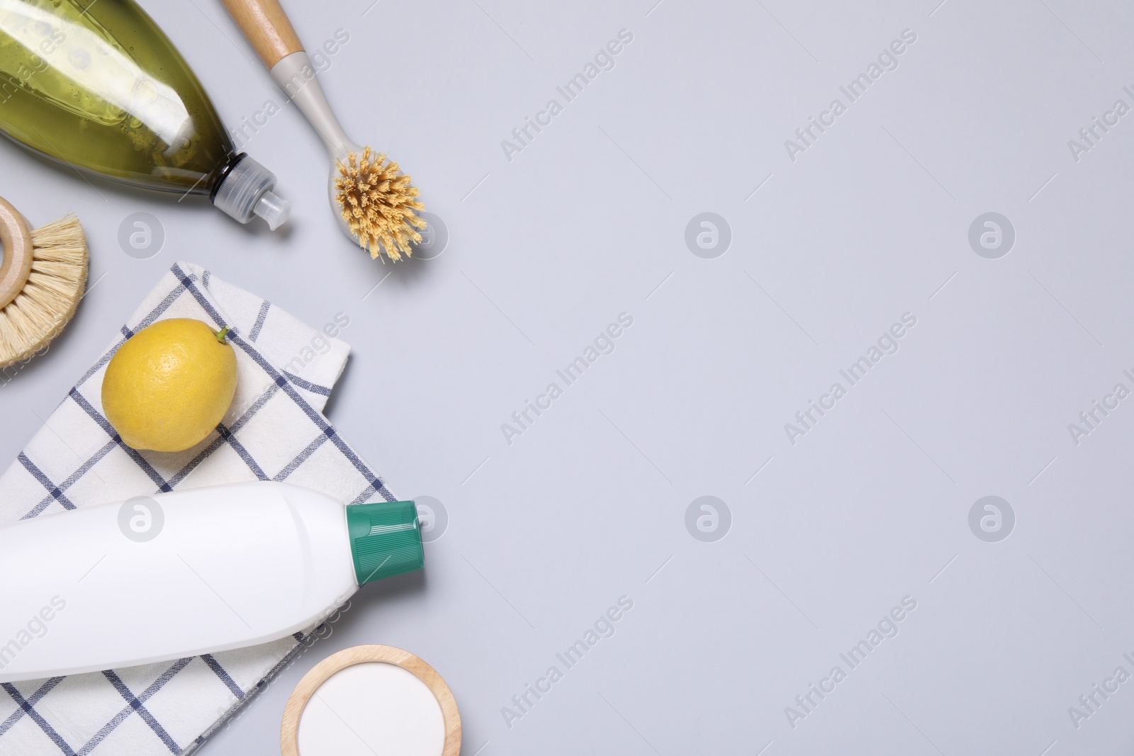 Photo of Flat lay composition with different cleaning supplies on light gray background, space for text