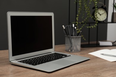 Photo of Cozy workplace with laptop and stationery on desk. Home office