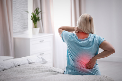 Image of Senior woman suffering from pain in back at home 