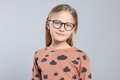 Photo of Portrait of cute girl in glasses on light grey background