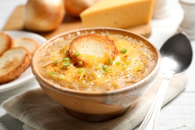 Photo of Tasty homemade french onion soup served on white table, closeup