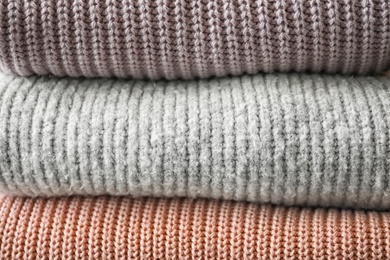 Photo of Stack of warm knitted clothes as background