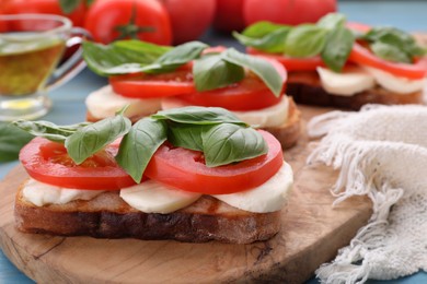 Photo of Delicious Caprese sandwiches with mozzarella, tomatoes and basil on table, closeup