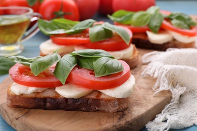 Delicious Caprese sandwiches with mozzarella, tomatoes and basil on table, closeup