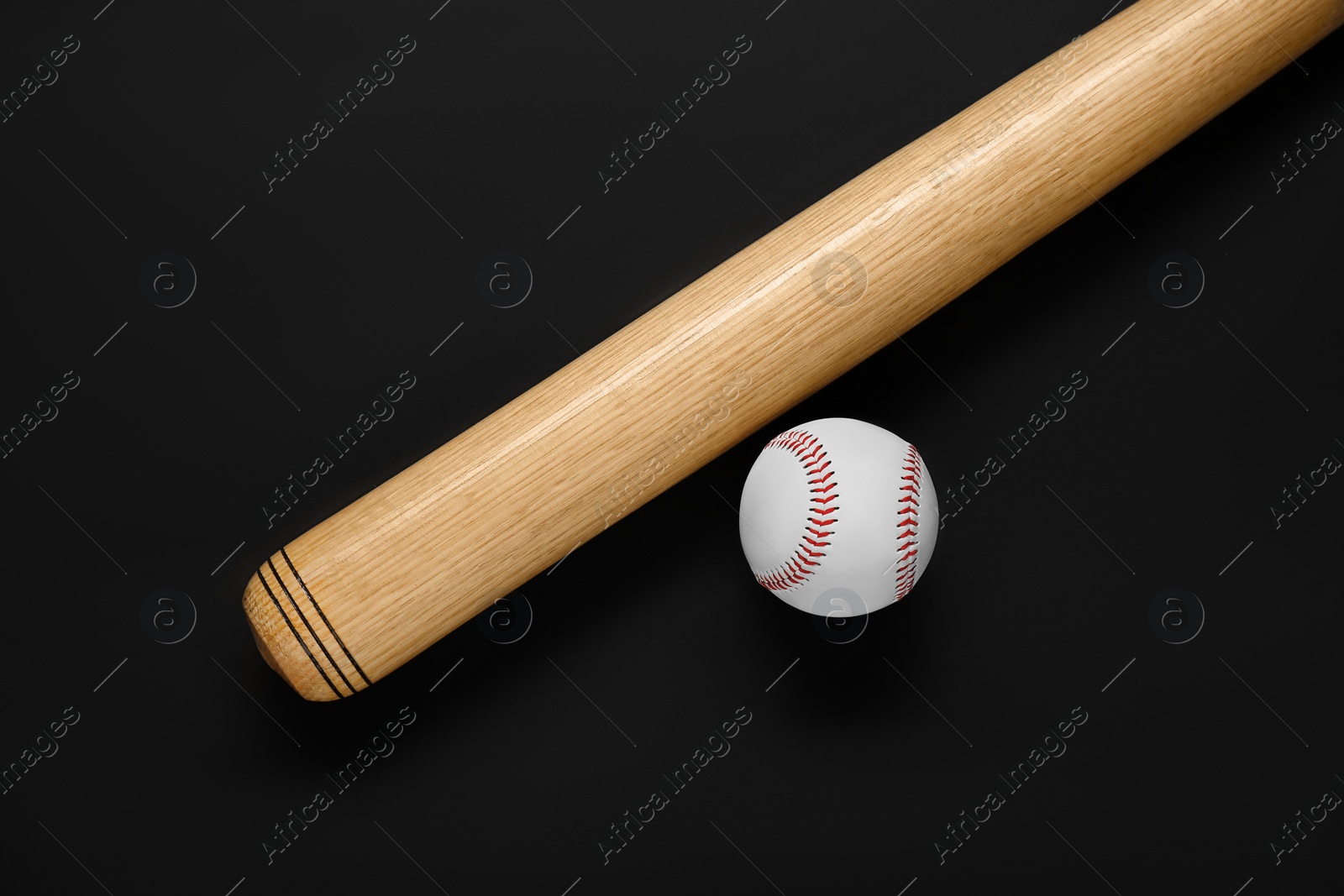 Photo of Wooden baseball bat and ball on black background, flat lay. Sports equipment