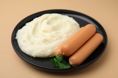 Photo of Delicious boiled sausages, mashed potato and parsley on beige background, closeup