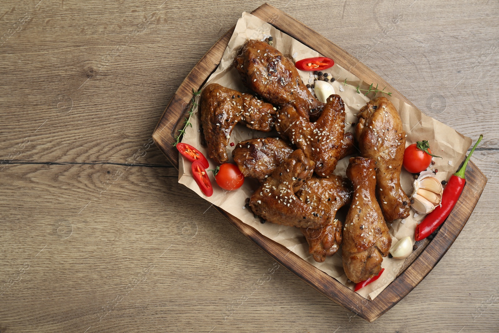 Photo of Tasty chicken glazed in soy sauce served on wooden table, top view. Space for text