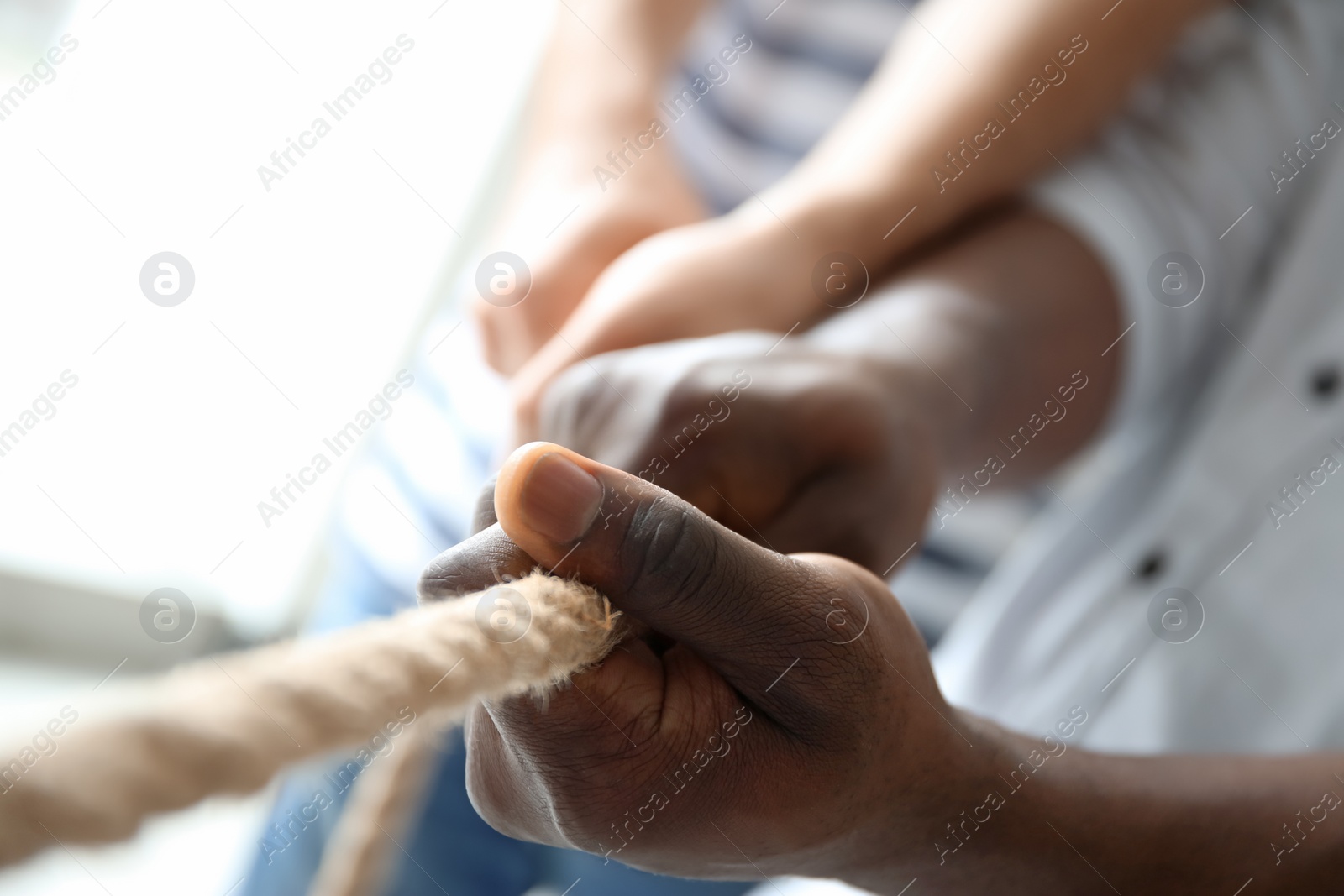Photo of People pulling rope together, closeup of hands. Unity concept
