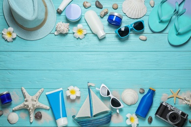 Flat lay composition with stylish beach accessories on light blue wooden background, space for text