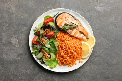 Plate with healthy food high in vegetable fats on grey textured table, top view