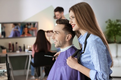 Hairdresser with happy client in beauty salon