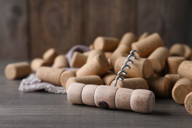 Corkscrew and wine bottle stoppers on wooden table, closeup