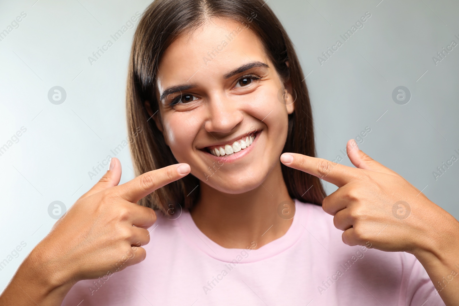 Photo of Young woman with healthy teeth on light background. Cosmetic dentistry