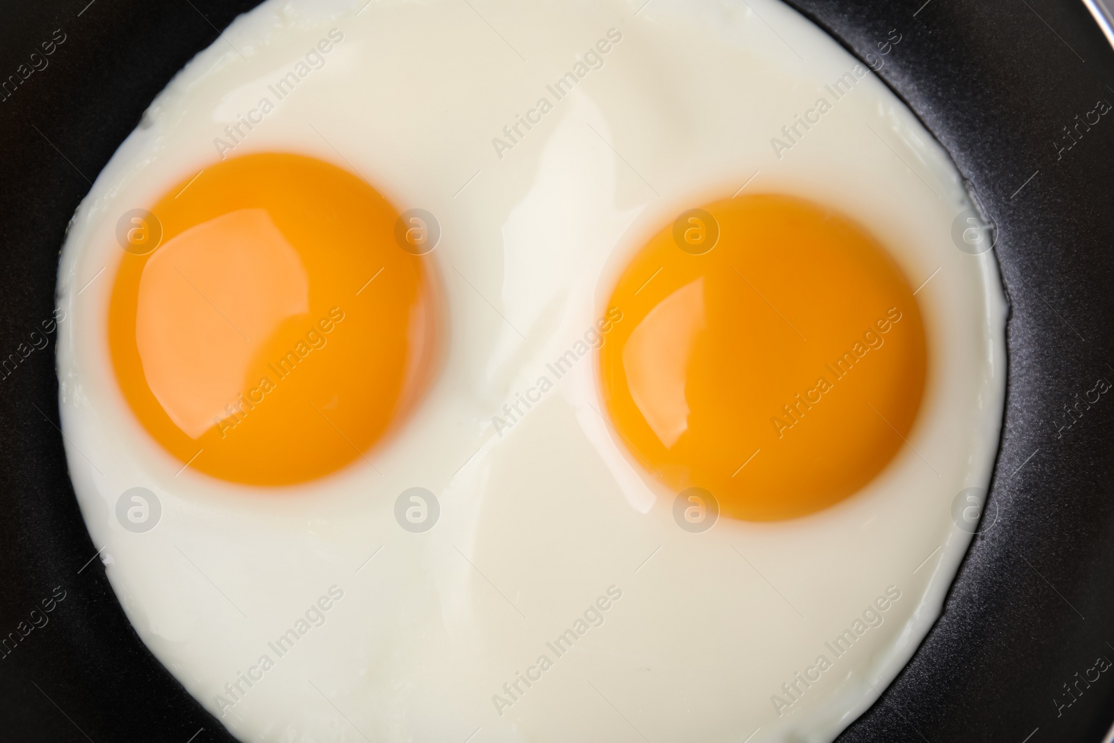 Photo of Tasty fried eggs in pan, top view