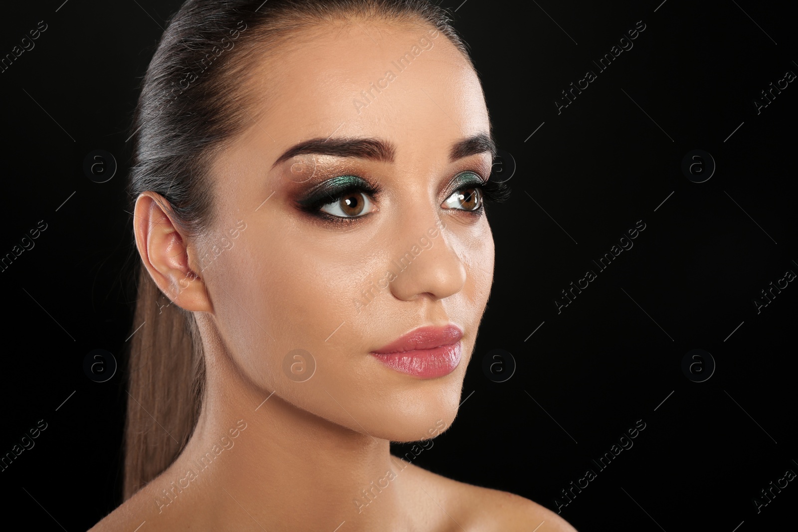 Photo of Portrait of young woman with eyelash extensions and beautiful makeup on black background