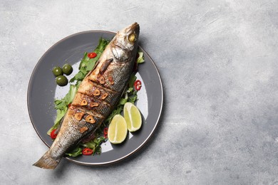 Photo of Delicious sea bass fish and ingredients on light grey table, top view. Space for text
