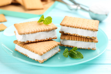 Photo of Sweet delicious ice cream cookie sandwiches on light blue wooden table