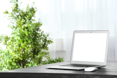 Photo of Laptop on desk in home office. Comfortable workplace