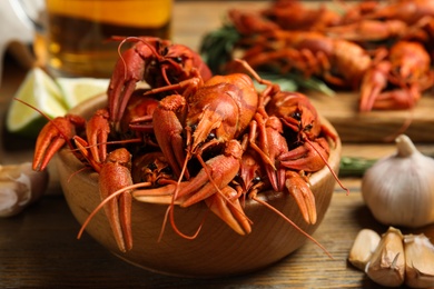 Photo of Composition with delicious red boiled crayfishes on wooden table, closeup