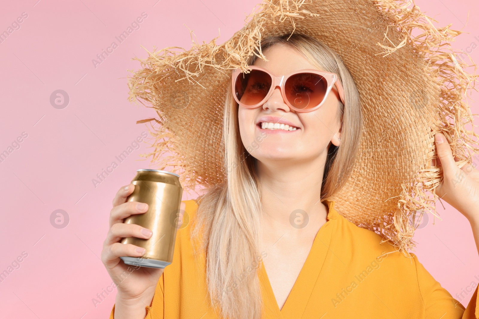 Photo of Beautiful happy woman holding beverage can on pink background