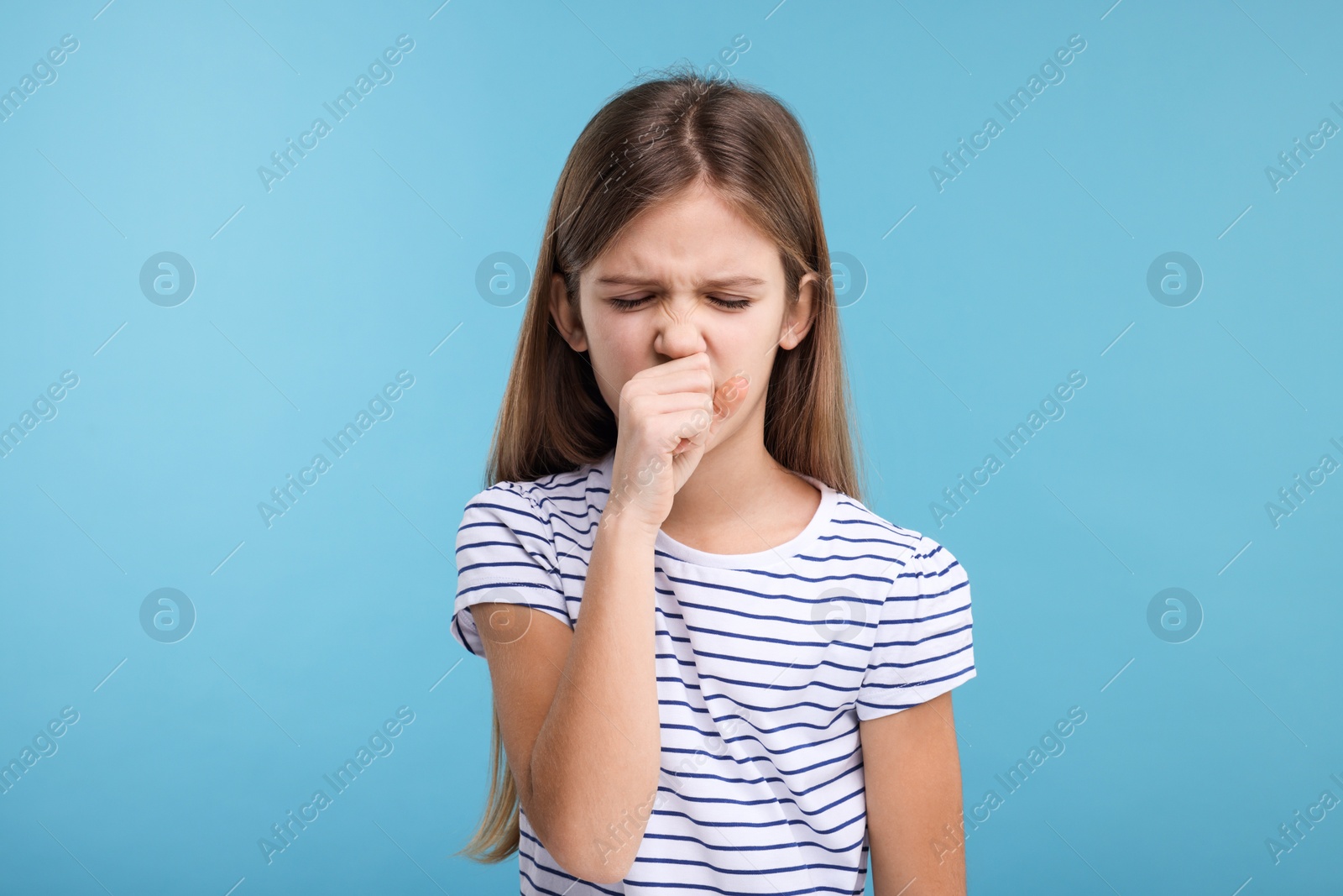 Photo of Sick girl coughing on light blue background