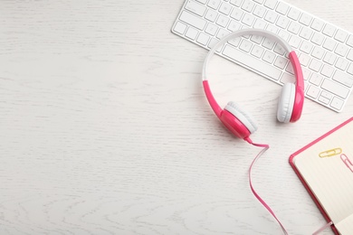 Flat lay composition with headphones and keyboard on table. Space for text