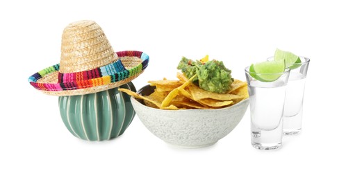 Photo of Mexican sombrero hat, ceramic cactus, tequila with lime, nachos chips and guacamole in bowl isolated on white