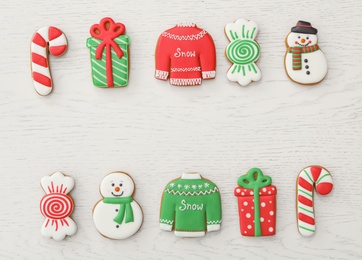 Photo of Different Christmas gingerbread cookies on white wooden table, flat lay. Space for text