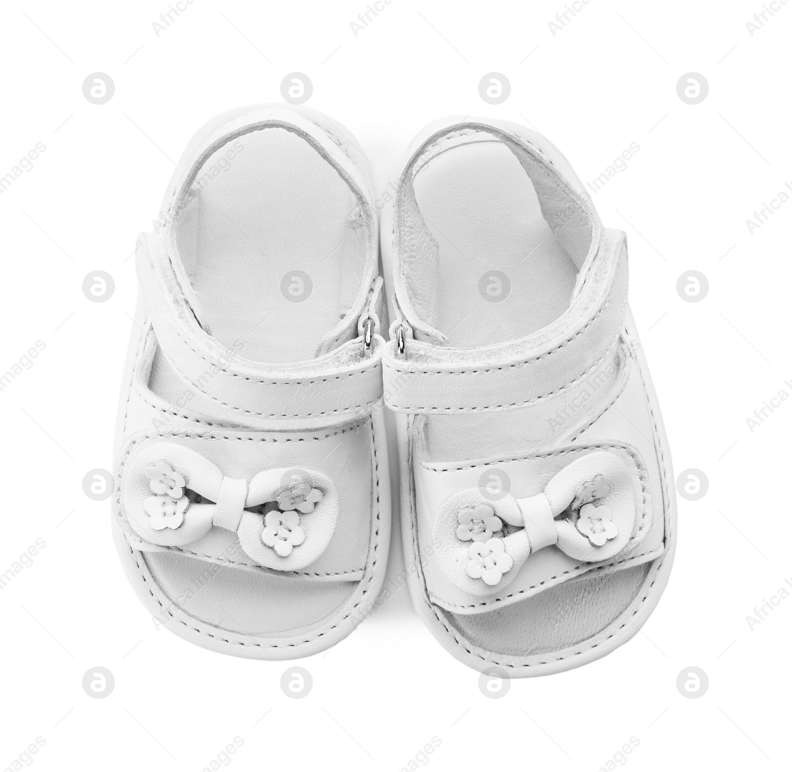 Photo of Pair of cute baby sandals decorated with bows on white background, top view