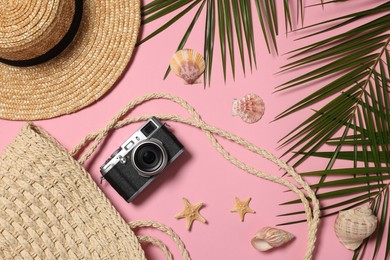 Photo of Flat lay composition with beach bag and camera on pink background