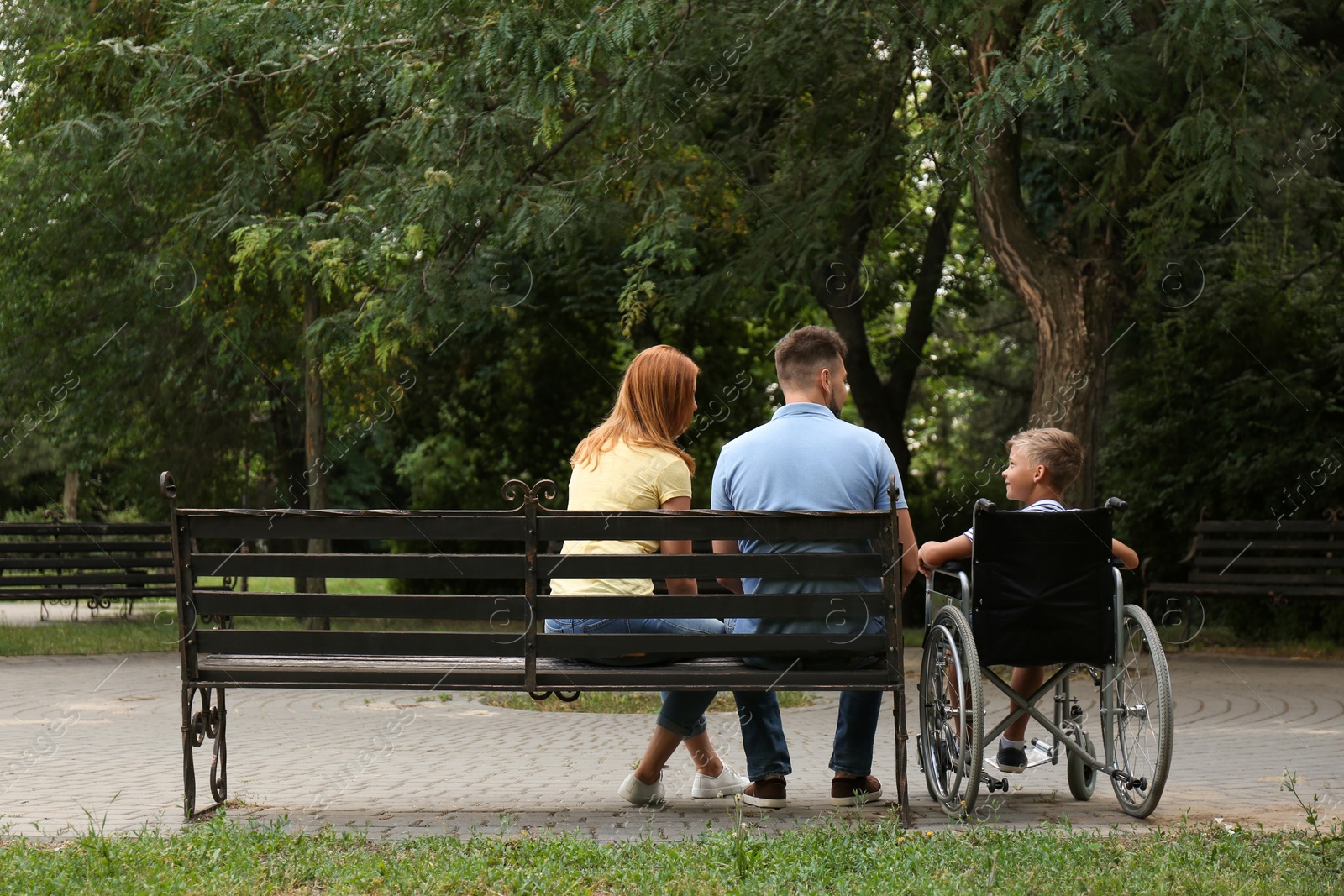 Photo of Boy in wheelchair with his family at park