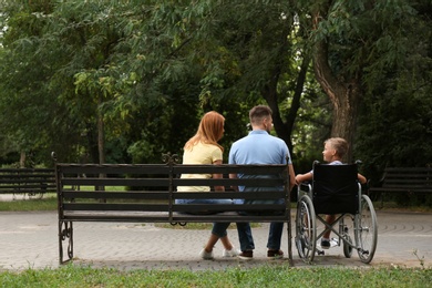 Photo of Boy in wheelchair with his family at park