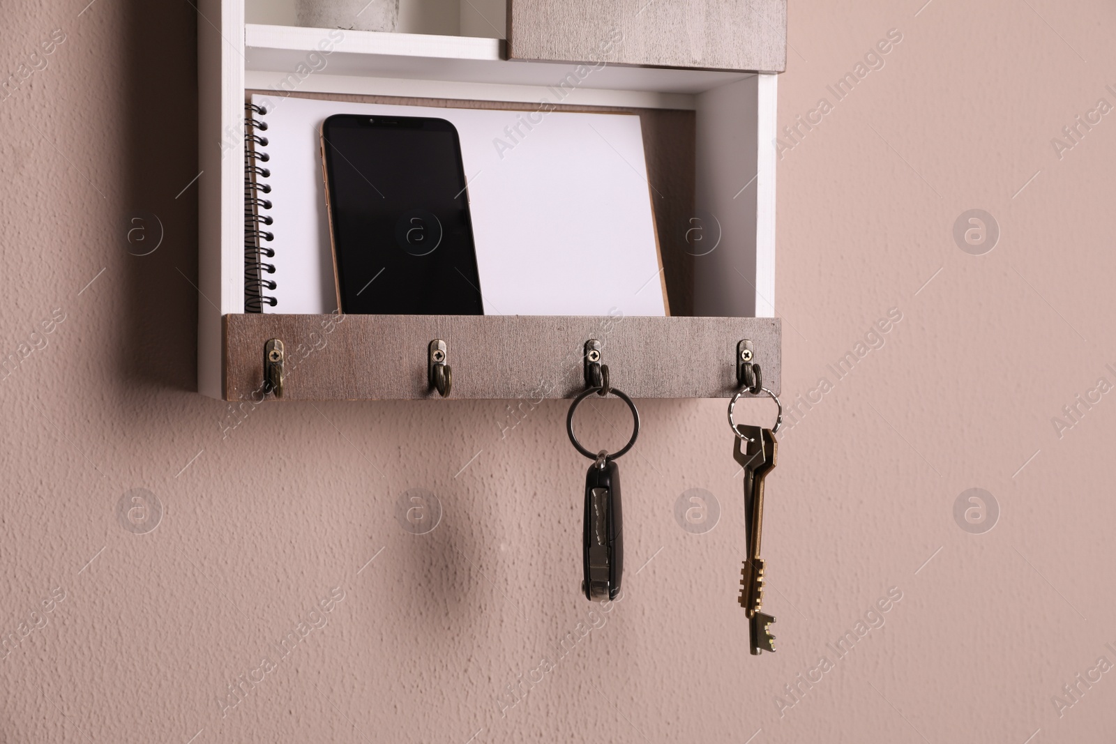 Photo of Wooden hanger for keys with different stuff on color wall