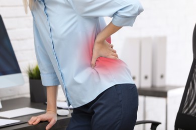 Image of Woman suffering from pain in lower back at workplace in office, closeup