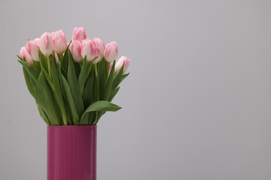 Photo of Beautiful bouquet of fresh pink tulips on light grey background. Space for text