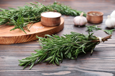 Photo of Bunch of fresh rosemary on wooden table