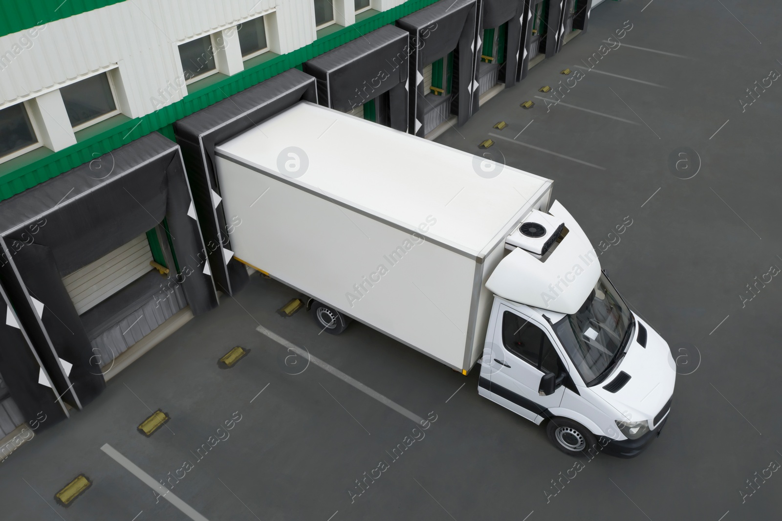 Image of Truck near loading dock of warehouse outdoors, aerial view. Logistics center