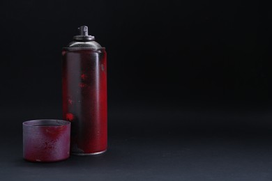Photo of One spray paint can with cap on dark background, space for text